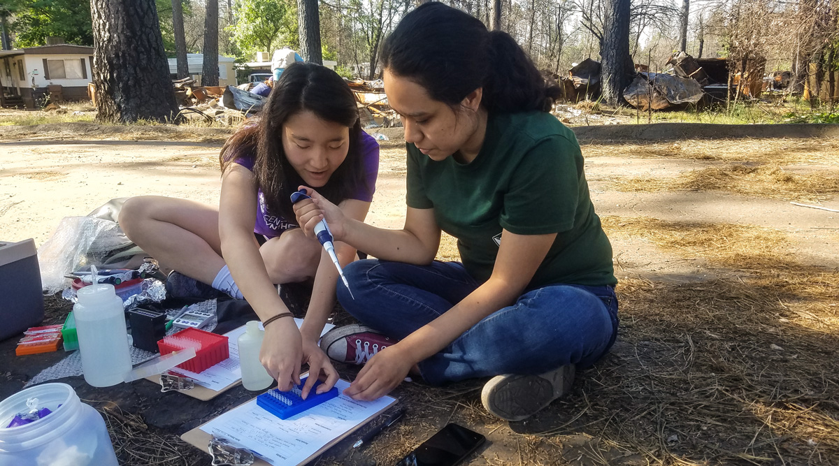 Two female students collecting water samples.