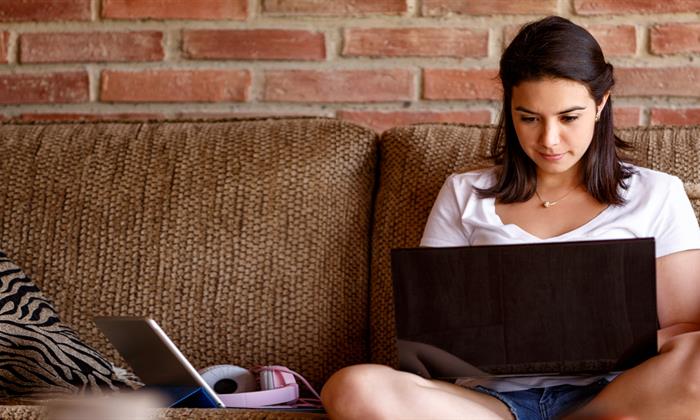 student using her laptop on the couch